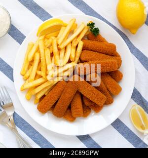 Hausgemachte Fischstäbchen und Pommes mit Tatarensauce, Draufsicht. Flach, über Kopf, von oben. Stockfoto