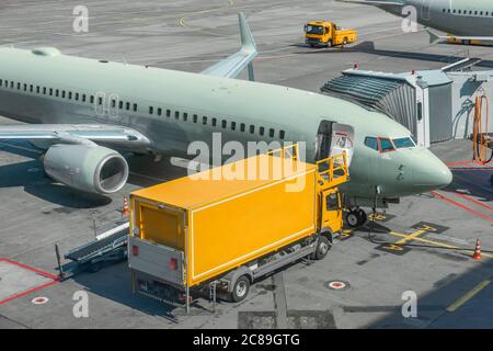 Gelber LKW neben einem Passagierflugzeug, Pre-Flight Service Flughafen Stockfoto