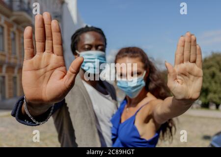 Porträt einer jungen europäischen Frau und eines afrikanischen Mannes in einer Straße. Stoppen Sie die Handbewegung des Coronavirus. Coronavirus-Ausbruchsvorbeugung. Verhütung von Verschmutzung und Krankheiten, Helsinki, Finnland. Hochwertige Fotos Stockfoto