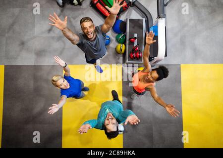 Fitness, Sport, Training, Gym, Erfolg und Lifestyle-Konzept. Gruppe glücklicher Freunde im Fitnessstudio Stockfoto