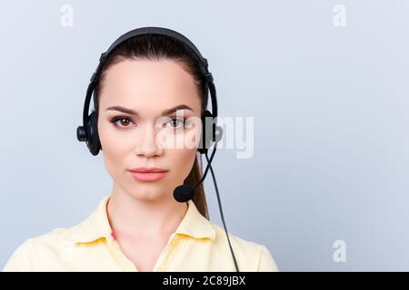 Porträt eines niedlichen brünette Call Center-Operator in einem Headset. Sie ist isoliert auf einem reinen hellen Hintergrund, sieht ernst Stockfoto