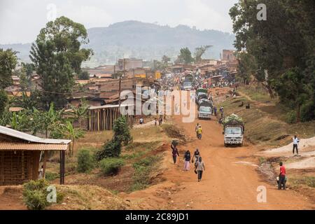 Eine staubige Landstraße führt zu einem geschäftigen Bergdorf am Fuße des Mount Elgon im Osten Ugandas. Stockfoto