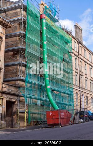 Eine Müllrutsche in einen sprung von Gerüsten auf einem Mietshaus Wohngebäude renoviert, Rose Street, Glasgow, Schottland, Großbritannien gerichtet Stockfoto