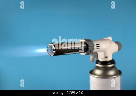 Gasbrenner mit blauer Feuerflamme auf blauem Hintergrund Stockfoto