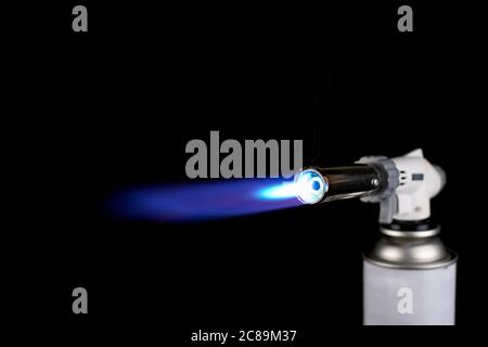 Gasbrenner mit blauer Feuerflamme auf schwarzem Hintergrund Stockfoto