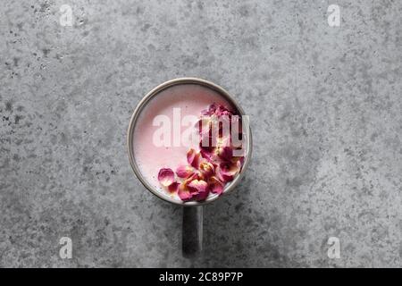 Eine Tasse Rosenmondmilch auf grauem Hintergrund. Draufsicht. Speicherplatz kopieren. Stockfoto