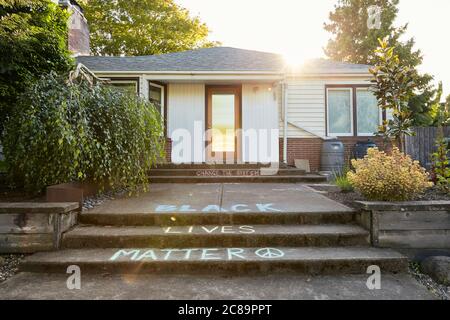 Portland, Oregon, USA - 2. Juni 2020: Low-Angle-Aufnahme eines Hauses im Stil der Mitte des Jahrhunderts mit dem Spruch "Black Lives Matter", vorne in Kreide geschrieben Stockfoto