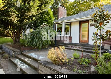 Portland, Oregon, USA - 2. Juni 2020: Seitenansicht eines Hauses im Stil der Mitte des Jahrhunderts mit dem Spruch "Black Lives Matter", der in Kreide auf der Vorderseite des hauses geschrieben wurde Stockfoto