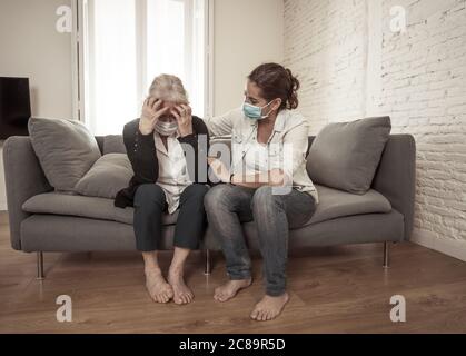 Depressive ältere Mutter und Tochter tragen medizinische Maske weinen und umarmen einander trauernden Verlust von Angehörigen kämpfen das Coronavirus. Menschen Stockfoto