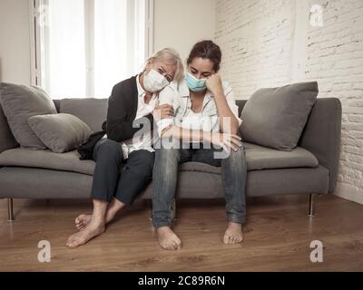 Depressive ältere Mutter und Tochter tragen medizinische Maske weinen und umarmen einander trauernden Verlust von Angehörigen kämpfen das Coronavirus. Menschen Stockfoto