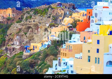 Santorini, Griechenland - 26. April 2019: Oia Stadtpanorama mit bunten Häusern, Schloss und Menschen Stockfoto