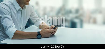 Telekommunikation - junger Geschäftsmann mit Telefon am Schreibtisch in modernen Büro. Business Hintergrund Kopie Raum Stockfoto