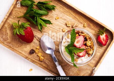 Holztablett mit Erdbeeren und Joghurt Dessert Stockfoto