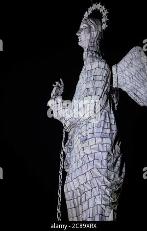 Vertikale Aufnahme der Loma El Panecillo in der Nacht in Quito, Ecuador Stockfoto