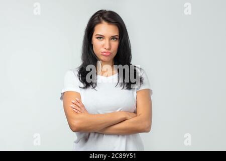 Verärgerung schönes Mädchen mit gekreuzten Armen stehen. Unzufriedenheit und Unzufriedenheit. Nahaufnahme Foto. Stockfoto