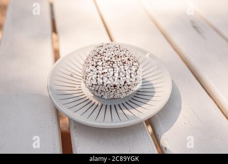 Leckere Schokoladenkugel mit Kokosnuss auf einem weißen Teller. Stockfoto