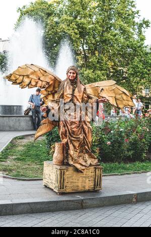 Ukraine, Odessa, Istanbul Park - 23. August 2019: Lebende Statue eines goldenen Engelsmädchens mit Flügeln im Istanbul Park in der Nähe des Odessa Handelshafens Stockfoto