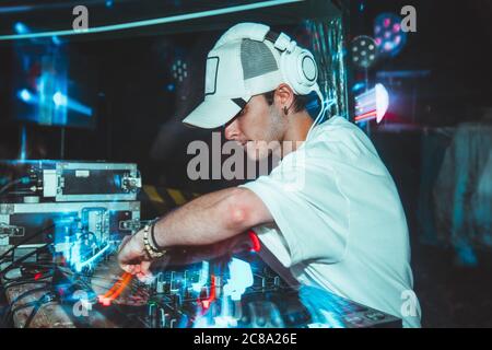 Charismatischer Discjockey am Plattenteller. DJ spielt auf den besten, berühmten CD-Player im Nachtclub während der Party. EDM, Parteikonzept. Stockfoto