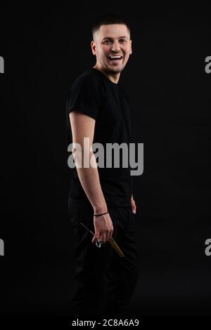 Barber Shop Konzept. Smiling Handsome Young Brunete in schwarz T-Shirt steht auf der Pure Stockfoto