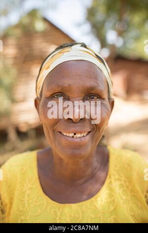 Porträt einer lächelnden Afrikanerin in gelb - Makueni County, Kenia, Ostafrika. Stockfoto