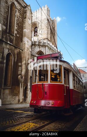 Traditionelle alte rote Straßenbahn Kabel elektrische Trolley über die Straßen von Alfama historischen Viertel von Lissabon, Portugal. Im Hintergrund die Glocke Stockfoto