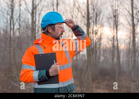 Forsttechniker posiert in Wald mit Merkzettel für die Sammlung von Daten Stockfoto