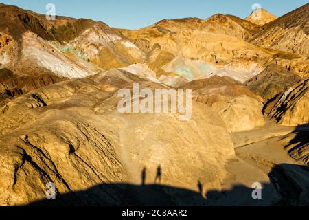 Landschaftlich reizvolle Aussicht auf die Artist Drive im Death Valley mit Schatten der Besucher auf den Felsen Stockfoto