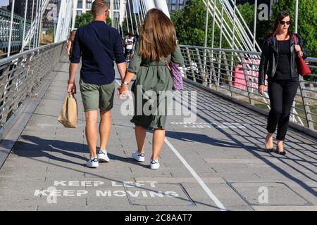 London, Großbritannien. Juli 2020. Die Meldungen „Keep Left, Keep Moving“ auf der Golden Jubilee Bridge erinnern die Londoner daran, Abstand zu halten und sich auf einer Seite der Brücke zu halten. Maskentragen und soziale Distanzierung scheinen zur „neuen Normalität“ zu werden, da sich immer mehr Menschen an die neuen Richtlinien und Empfehlungen gewöhnen. Kredit: Imageplotter/Alamy Live Nachrichten Stockfoto