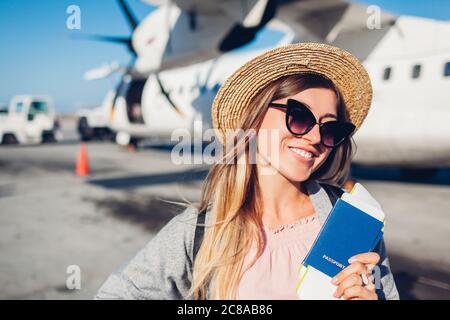 Frau Reisende im Flugzeug mit Passkarten. Glücklicher Passagier mit Rucksack flugbereit Stockfoto