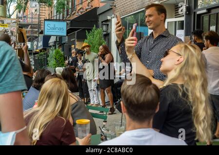 Menschenmassen versammeln sich außerhalb von Bathtub Gin im New Yorker Stadtteil Chelsea, während die Bar am Donnerstag, dem 16. Juli 2020, ihren 9. Geburtstag mit einer Party feiert. NYS Gov. Andrew Cuomo wird Pläne für die Stadt bekannt geben, in Phase 4 der Wiedereröffnung einzutreten, aber keine zusätzlichen Indoor-Aktivitäten werden erlaubt sein, unter anderem unter Berufung auf Probleme mit Bars und Restaurants, die nicht den Bestimmungen entsprechen. (© Richard B. Levine) Stockfoto