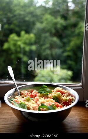 Vor einem Fenster. Couscous mit Minze, Tomaten, Zitrone und Olivenöl. Stockfoto