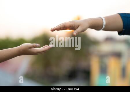 Shallow-Fokus-Aufnahme der Hände von zwei Personen zu erreichen Miteinander ausziehen Stockfoto