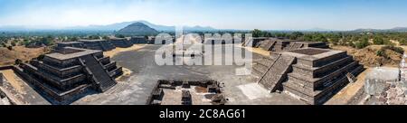 Teotihuacan Pyramide des Mondes Blick Mexiko | SAN JUAN TEOTIHUACÁN, Mexiko — Ein Panorama von der Pyramide des Mondes rahmt die Avenue der Toten, die auf die Pyramide der Sonne zuläuft, und fängt die gesamte zeremonielle Achse einer der größten geplanten Städte der antiken Welt ein. Flankierende Plattformen stützten einst Tempel und Elitewohnungen in einer Metropole, deren Bevölkerungszahl laut Studien zur Blütezeit etwa 100.000 Einwohner betrug. Stockfoto