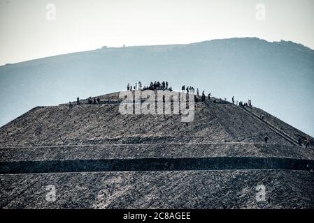 TEOTIHUACAN, Mexiko – Ein Blick auf den Gipfel der Sonnenpyramide von der Spitze der Mondpyramide in Teotihuacan. Diese Perspektive zeigt die monumentale Größe des größten Bauwerks der antiken Stadt und bietet einen einzigartigen Einblick auf die flache Plattform und die vielen Besucher, die dieses architektonische Wunder erkunden. Stockfoto