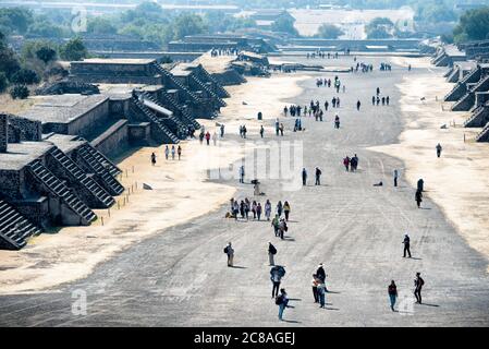 Pyramide der Mondallee der Toten Teotihuacan Mexiko // TEOTIHUACAN, Mexiko – Ein Panoramablick vom Gipfel der Mondpyramide offenbart die monumentale Größe dieser antiken mesoamerikanischen Metropole. Die riesige Sonnenkyramide, die sich etwa 65 Meter (213 Fuß) hoch erhebt, dominiert die Landschaft auf der linken Seite als eines der größten Bauwerke im präkolumbischen Amerika. Die Avenue of the Dead erstreckt sich nach Süden nach rechts und bildet die zentrale Achse des Stadtplans von Teotihuacan, der einst die wichtigsten Zeremonienkomplexe der Stadt verband. Teotihuacan blühte zwischen ungefähr Stockfoto