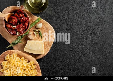 Zutaten zum Verkleben von Pasta mit sonnengetrockneten Tomaten und Parmesan. Italienische Küche. Bild mit Kopierbereich Stockfoto