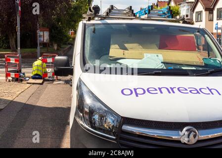 OpenReach-Mitarbeiter mit Van. Telekommunikation arbeitet im Gange mit männlichen Arbeiten in Pflaster-Access-Panel. Techniker mit Sicherheitsbarrieren Stockfoto