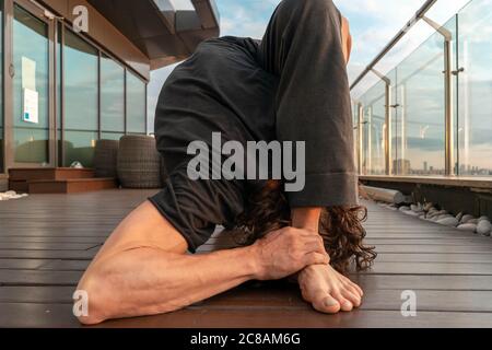 Athletic Sporty Man Stretching Outdoor Im Skyscraper. Leben In Harmonie Mit Dem Selbst. Innerlich Glücklich. Asana. Bild Mit Rauschen Und Körnern Stockfoto
