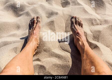 Ein Mann, der Füße und Beine entspannt an einem Strand, Mexiko. Stockfoto