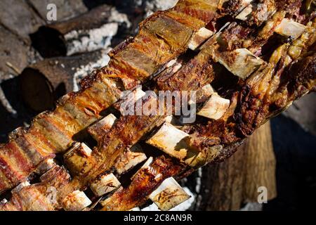 Asado, traditionelles Grillgericht in Argentinien, gebratenes Fleisch auf einem gekreuzten vertikalen Grills gekocht Stockfoto