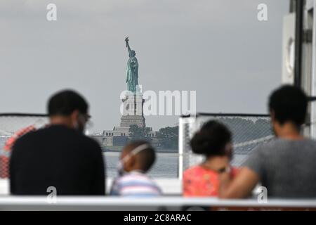 New York City, USA. Juli 2020. Die Familie Fleming, die von Seattle aus eine Fähre nach Liberty Island nimmt, ist nun für Besucher im Rahmen der Wiedereröffnung von New York City Phase 4 zugänglich, aber der Zugang zur Freiheitsstatue selbst, einschließlich Krone und Sockel, bleibt aufgrund der COVID-19-Beschränkungen geschlossen. New York, NY, 22. Juli 2020. Seit der Eröffnung am Montag waren die üblichen Massen von Zehntausenden von Menschen abwesend, stattdessen wurde ein langsamer Strom von nur wenigen hundert Touristen gezählt, die „Lady Liberty“ besuchen. (Anthony Behar/Sipa USA) Quelle: SIPA USA/Alamy Live News Stockfoto