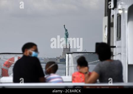 New York City, USA. Juli 2020. Die Familie Fleming, die von Seattle aus eine Fähre nach Liberty Island nimmt, ist nun für Besucher im Rahmen der Wiedereröffnung von New York City Phase 4 zugänglich, aber der Zugang zur Freiheitsstatue selbst, einschließlich Krone und Sockel, bleibt aufgrund der COVID-19-Beschränkungen geschlossen. New York, NY, 22. Juli 2020. Seit der Eröffnung am Montag waren die üblichen Massen von Zehntausenden von Menschen abwesend, stattdessen wurde ein langsamer Strom von nur wenigen hundert Touristen gezählt, die „Lady Liberty“ besuchen. (Anthony Behar/Sipa USA) Quelle: SIPA USA/Alamy Live News Stockfoto