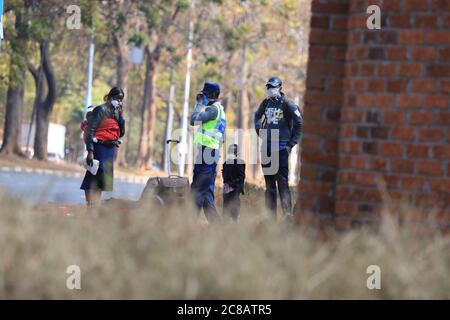 Harare, Simbabwe. Juli 2020. Ein Polizist mit Gesichtsmaske spricht am 22. Juli 2020 zu einer Frau in Harare, Simbabwe. Der simbabwische Präsident Emmerson Mnangagwa kündigte am Dienstag eine Reihe strengerer Sperrmaßnahmen an, darunter die Verhängung einer Ausgangssperre von 18:00 bis 6:00 Uhr, um die steigenden Fälle von COVID-19 einzudämmen. Quelle: Wanda/Xinhua/Alamy Live News Stockfoto