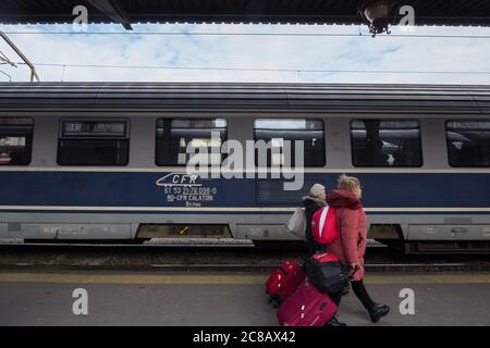 BUKAREST, RUMÄNIEN - 15. FEBRUAR 2020: CFR Calatori Logo auf dem Intercity-Zug in Gara de Nord, Hauptbahnhof von Bukarest mit Passagieren Passin Stockfoto