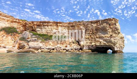 Blick auf die Klippen und Höhlen von Benagil von der Meerseite. Schöne natürliche Meeresgrotten mit smaragdgrünem Wasser und Atlantischem Ozean Stockfoto