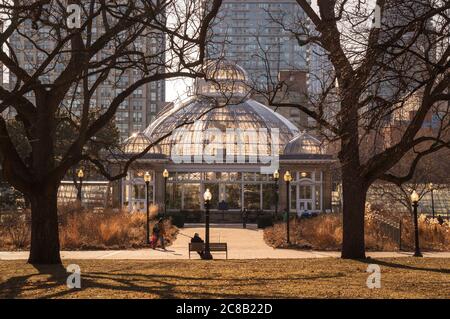 Frühlingshafter Sonnenuntergang im Toronto Allan Gardens Park mit einem Gewächshaus vor Hochhäusern Stockfoto