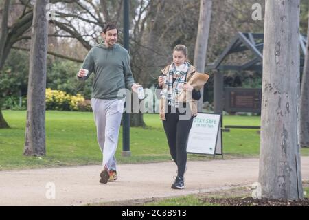Melbourne, Australien 23. Juli 2020, ein Mann und eine Frau missachtet die Anforderung, eine Gesichtsmaske unter gesundheitlichen Richtungen zu tragen, die heute in Kraft getreten ist, während sie auf dem Tan Walking Track rund um Melbournes Botanischen Gärten spazieren. Kredit: Michael Currie/Alamy Live Nachrichten Stockfoto