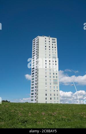 Terneuzen, Niederlande, 12. Juli 2020, großes weißes Appartementhaus auf einem grünen Hügel mit blauem Himmel und Wolken Stockfoto