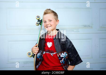 Auf diesem atemberaubenden Foto zeigen sich die Skateboard-Fähigkeiten eines blonden Jungen Stockfoto