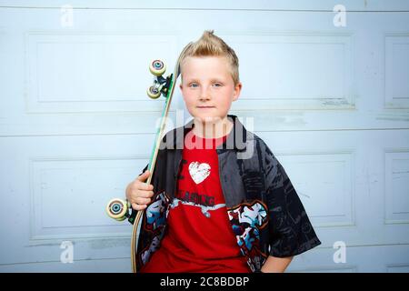 Auf diesem atemberaubenden Foto zeigen sich die Skateboard-Fähigkeiten eines blonden Jungen Stockfoto